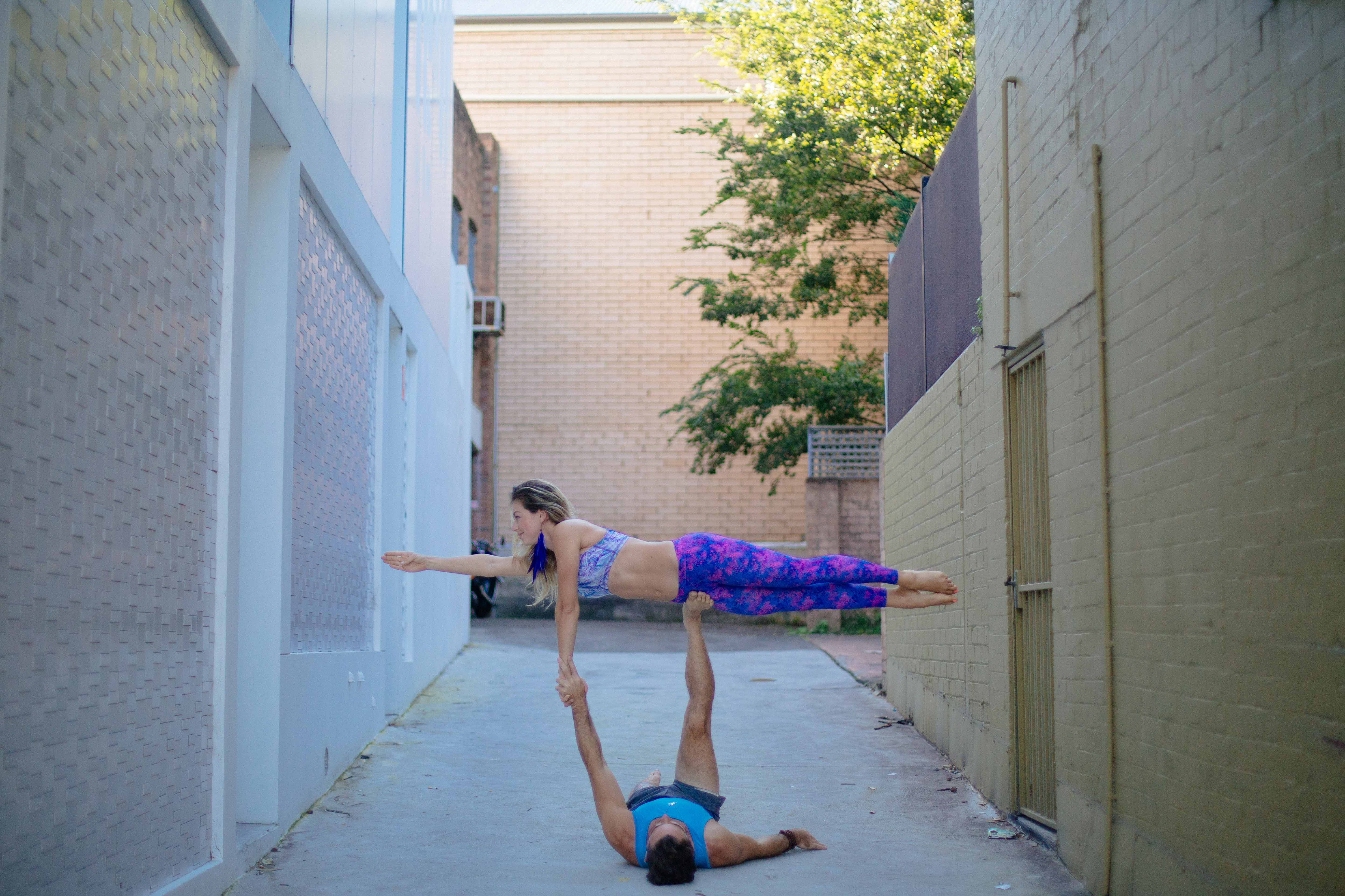 Two yogis holding headstands on an empty city promenade at dawn
