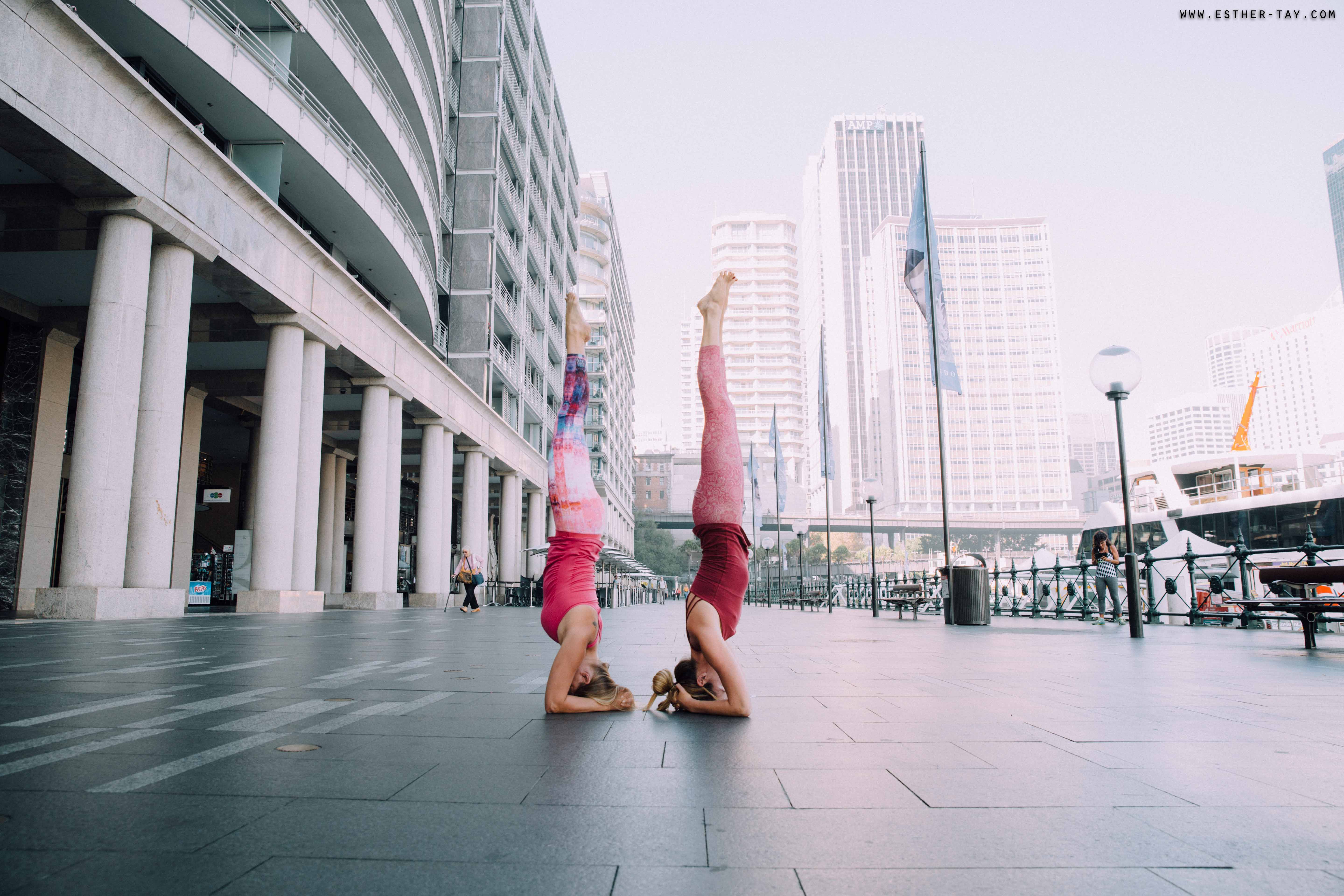 A woman in a deep lunge stretch on a palm-lined city street